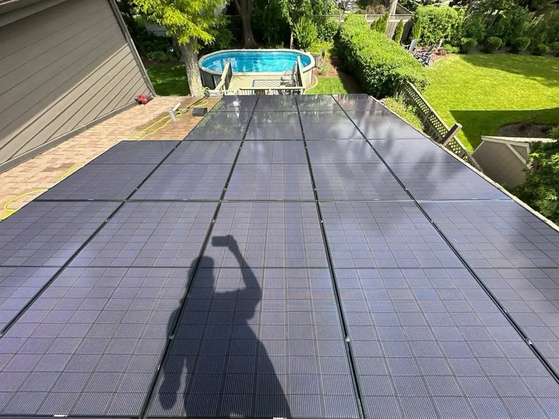 Pane Pal Solar technician using a water-fed pole and soft brush to clean bird droppings off residential solar panels in Glenview
